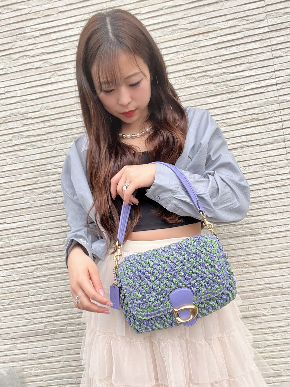 パープル系のショルダーバッグを着用したレディースの春コーディネートの3枚目の写真