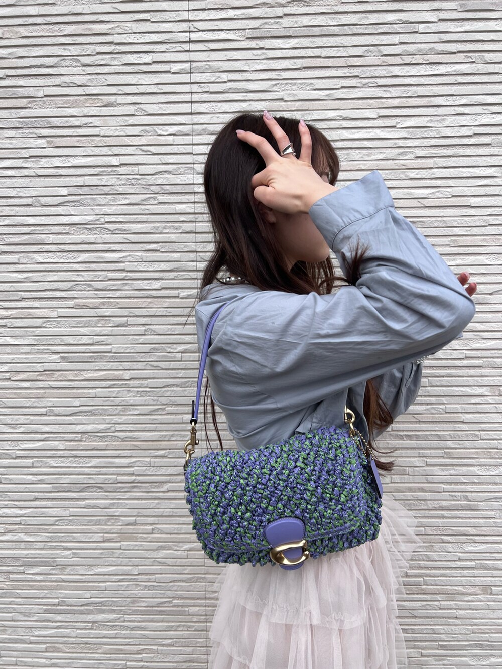 パープル系のショルダーバッグを着用したレディースの春コーディネートの2枚目の写真