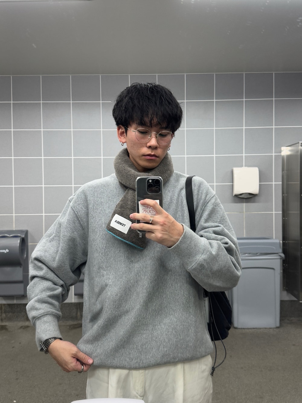 ホワイト系のデニムパンツ、グレー系のスウェット、ブラック系のハンドバッグを着用したメンズの秋コーディネートの3枚目の写真