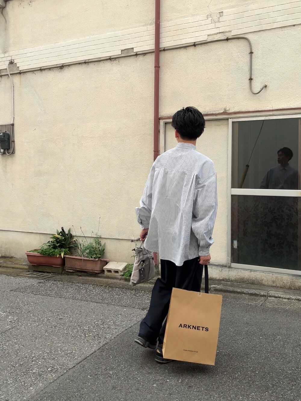 グレー系のシャツ/ブラウス、ブルー系のパンツ、グレー系のハンドバッグを着用したメンズの春コーディネートの3枚目の写真