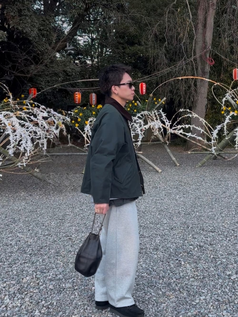 グリーン系のブルゾン、グレー系のスウェットパンツ、ブラック系のモカシン/デッキシューズを着用したメンズの冬コーディネートの3枚目の写真