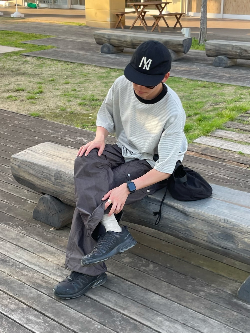 ホワイト系のTシャツ/カットソー、グレー系のカーゴパンツ、ブラック系のスニーカーを着用したメンズの夏コーディネートの2枚目の写真