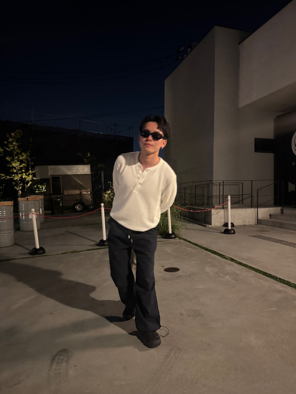 ホワイト系のTシャツ/カットソー、ブルー系のカーゴパンツ、ブラック系のサンダルを着用したメンズの秋コーディネートの3枚目の写真