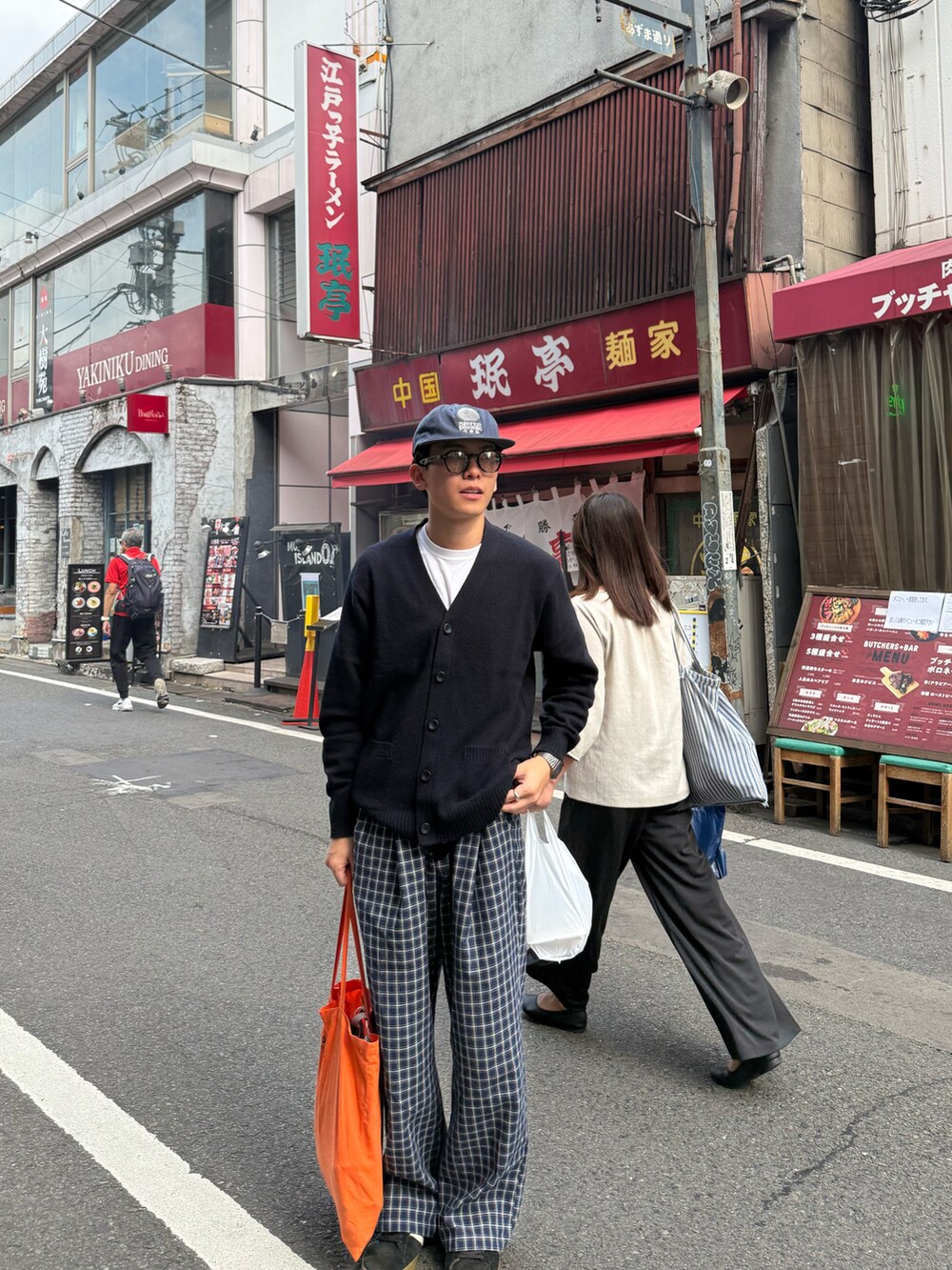 ブルー系のニット/セーター、ブルー系のパンツ、ブラック系のスニーカーを着用したメンズの秋コーディネートの2枚目の写真