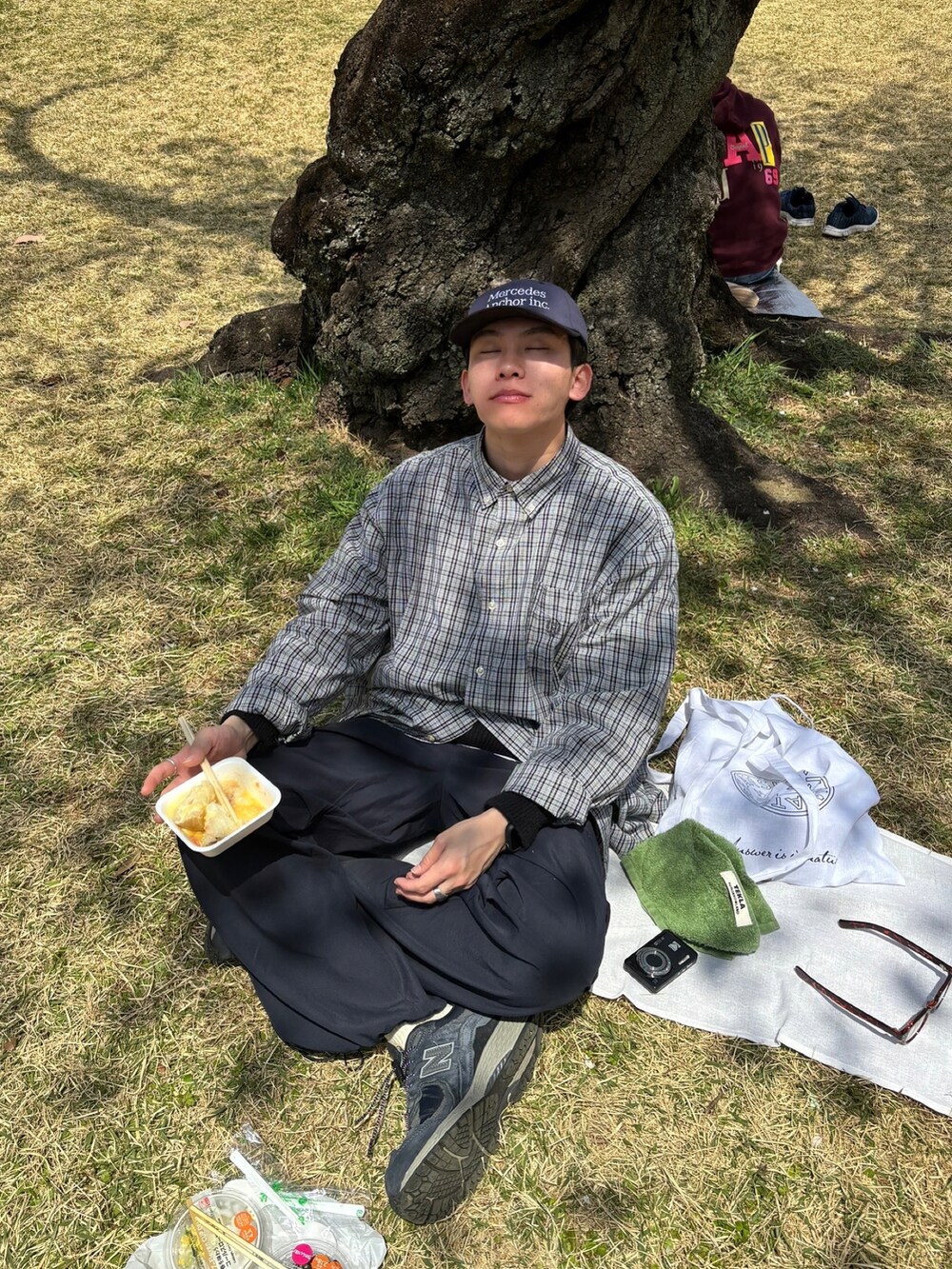 ブルー系のカーゴパンツ、ブルー系のスニーカー、ブルー系のキャップを着用したメンズの春コーディネートの2枚目の写真