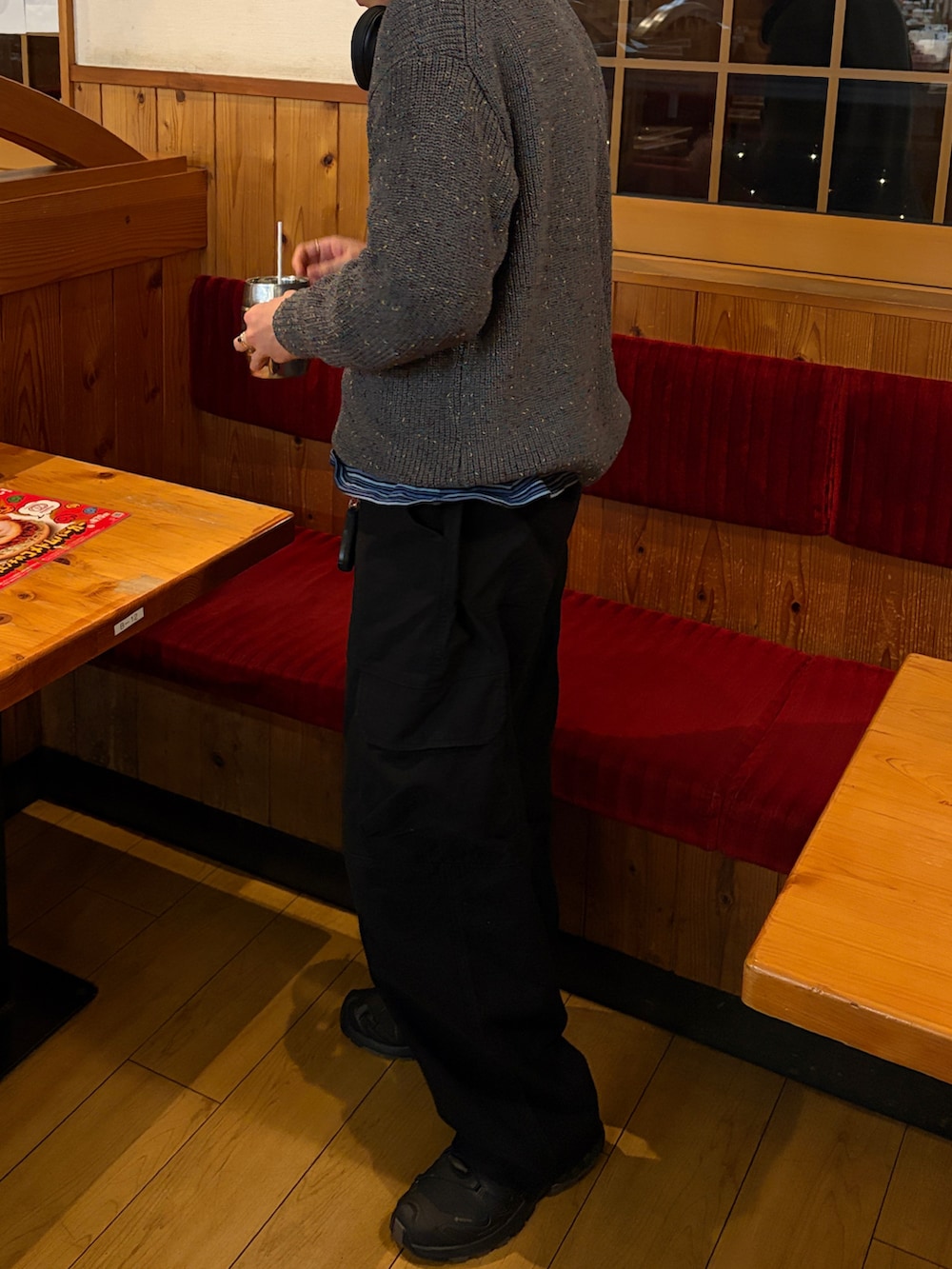 グレー系のニット/セーター、ブラック系のカーゴパンツ、ブラック系のスニーカーを着用したメンズの春コーディネートの2枚目の写真