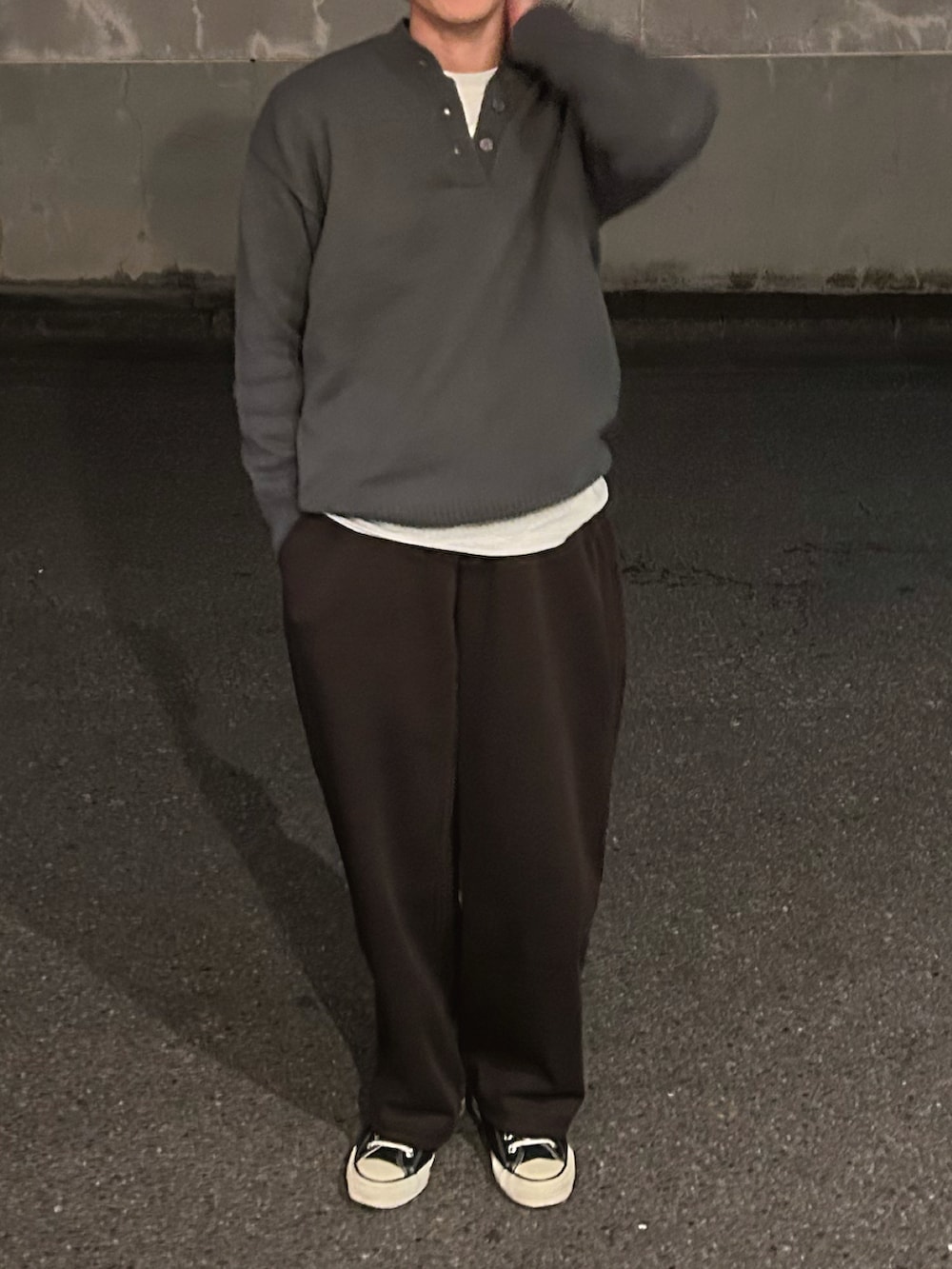 グレー系のニット/セーター、ブラウン系のスウェットパンツ、ブラック系のスニーカーを着用したメンズの冬コーディネートの2枚目の写真
