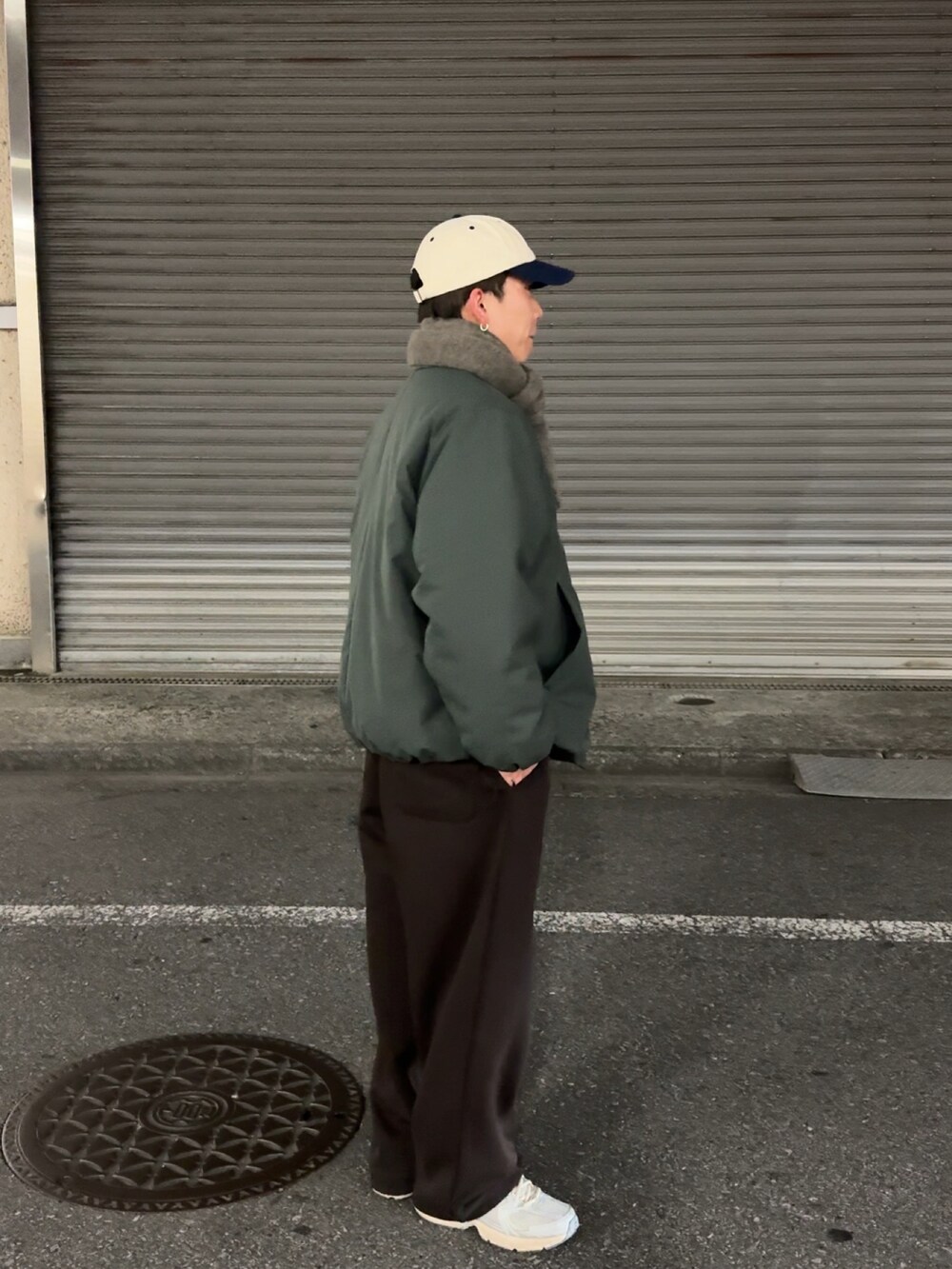 グリーン系のジャケット/アウター、ブラウン系のスウェットパンツ、シルバー系のスニーカーを着用したメンズの冬コーディネートの2枚目の写真