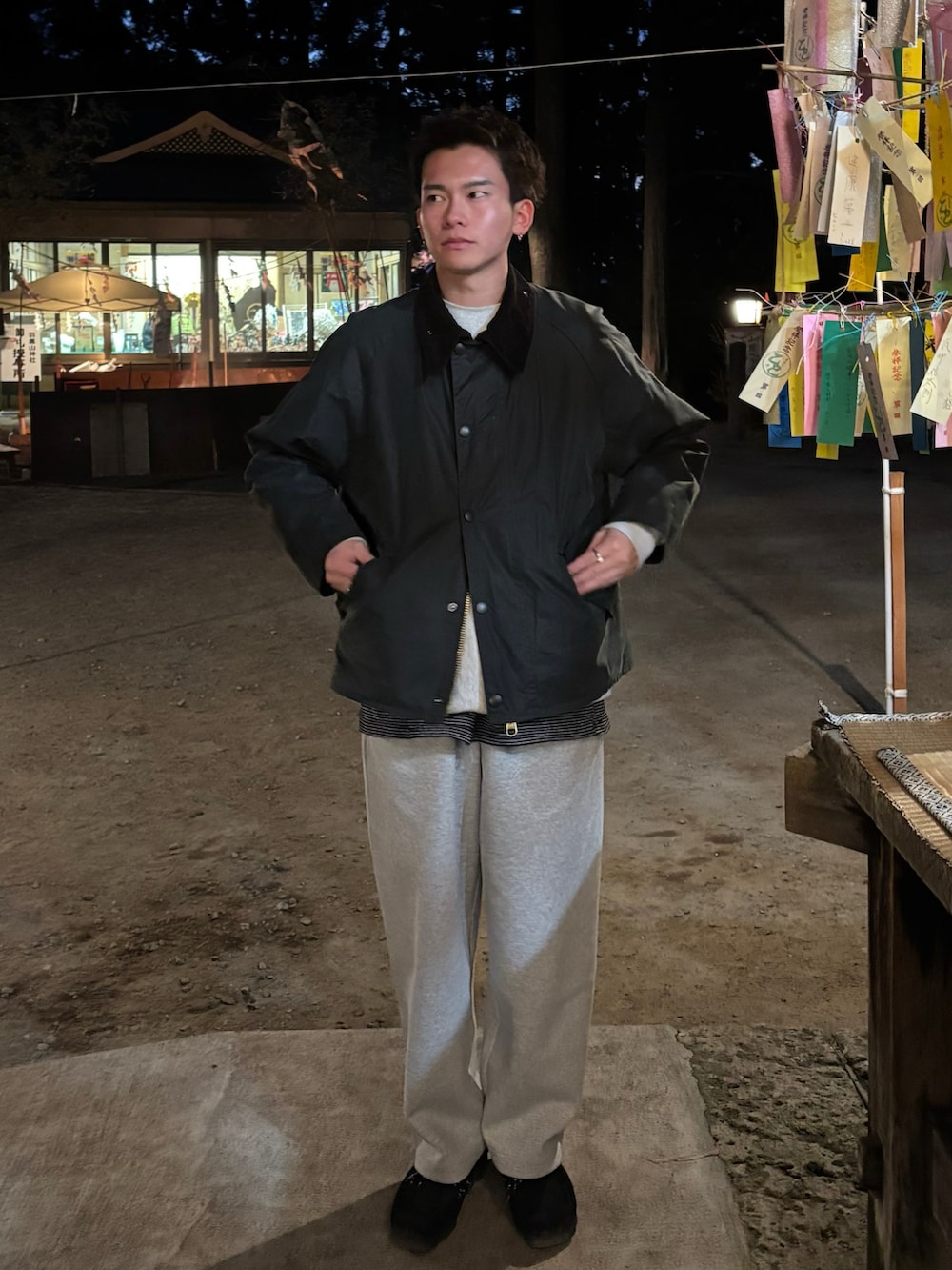 グリーン系のブルゾン、グレー系のスウェットパンツ、ブラック系のモカシン/デッキシューズを着用したメンズの冬コーディネートの2枚目の写真