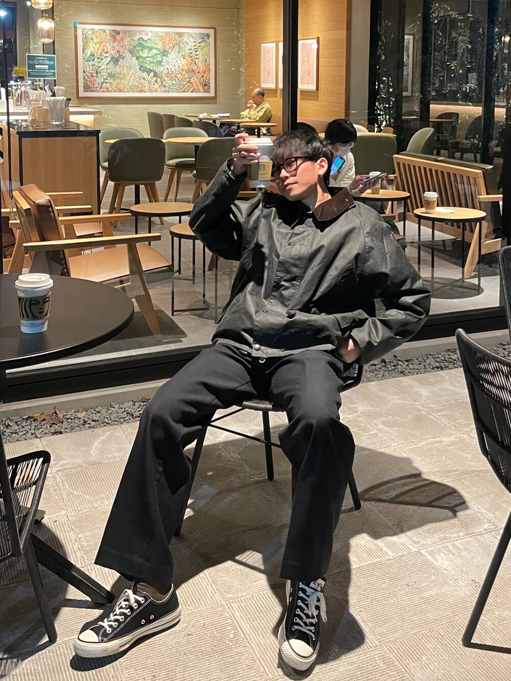 ブラック系のスラックス、ブラック系のスニーカー、グリーン系のジャケット/アウターを着用したメンズの冬コーディネートの2枚目の写真