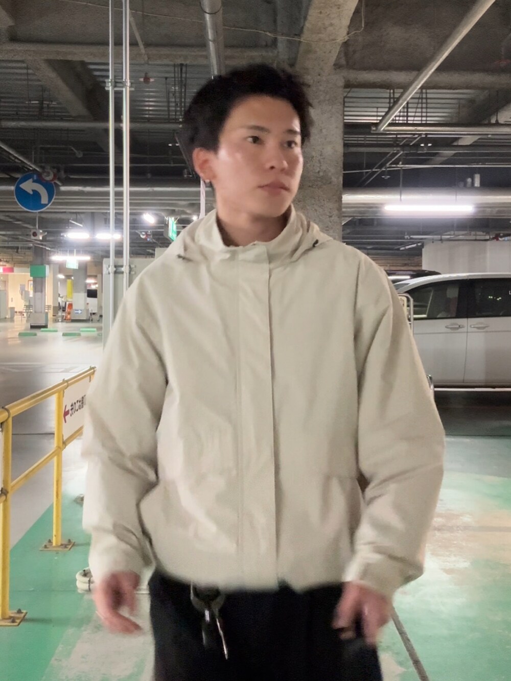 ホワイト系のブルゾン、ブラック系のスラックス、ブルー系のスニーカーを着用したメンズの冬コーディネートの3枚目の写真