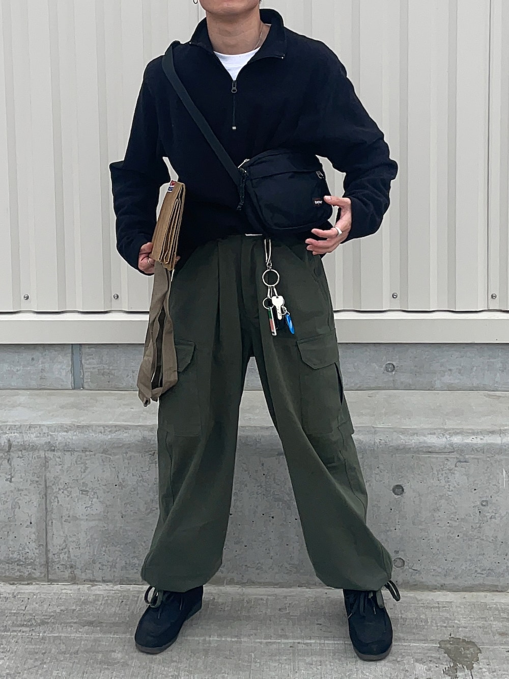 ブラック系のその他トップス、グリーン系のカーゴパンツ、ブラック系のスニーカーを着用したメンズの春コーディネートの2枚目の写真
