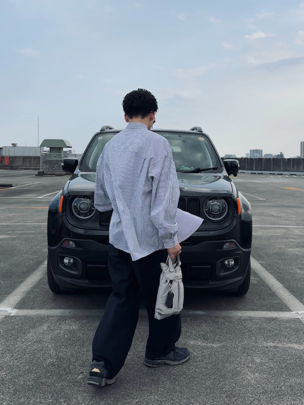 グレー系のシャツ/ブラウス、ブルー系のパンツ、グレー系のハンドバッグを着用したメンズの春コーディネートの2枚目の写真