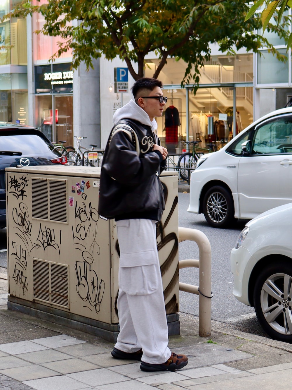 グレー系のパーカー、グレー系のスウェットパンツ、ブラック系のスタジャンを着用したメンズの冬コーディネートの2枚目の写真