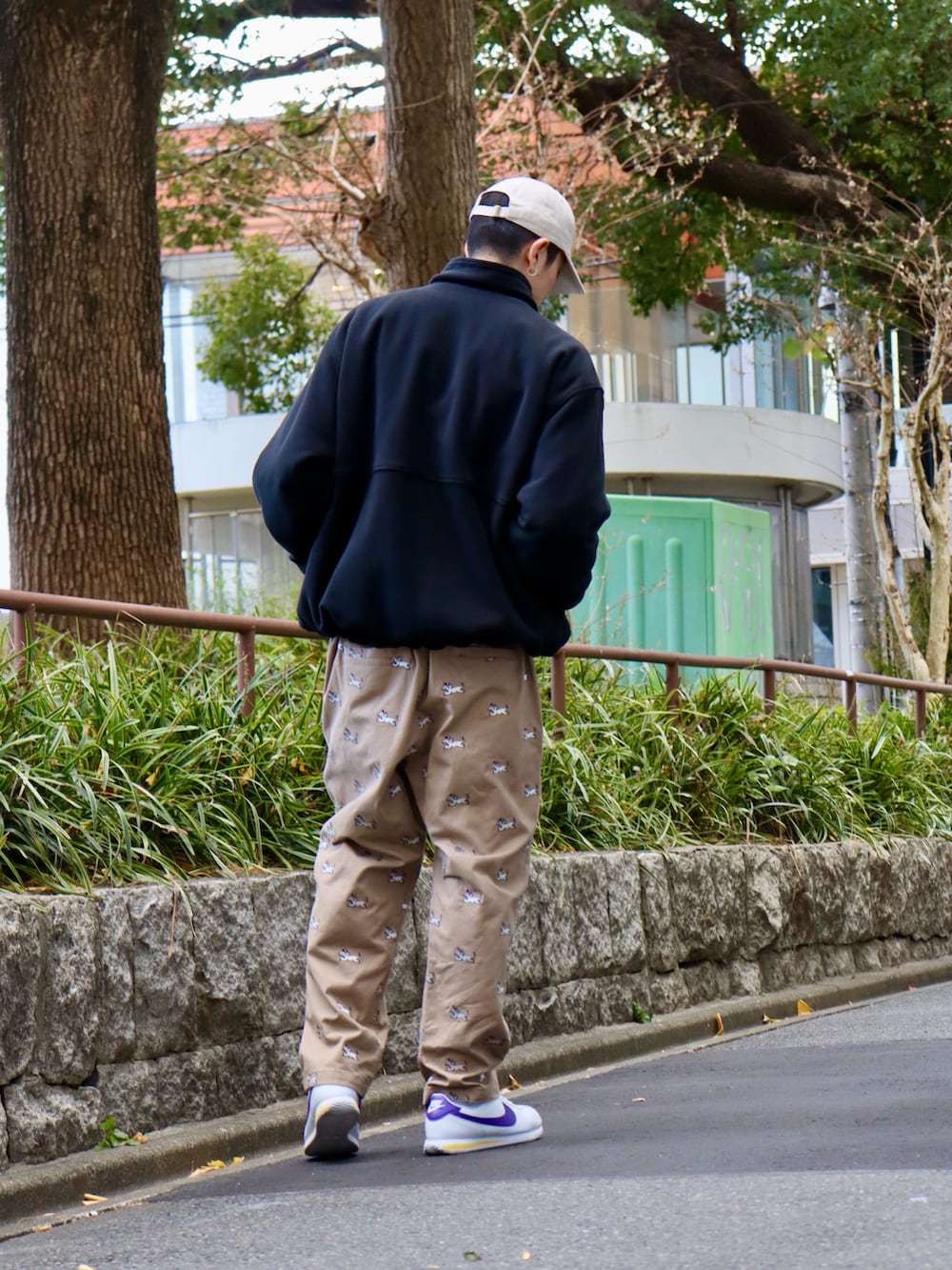 ブラック系のナイロンジャケット、ブラック系のスウェット、ベージュ系のチノパンツを着用したメンズの冬コーディネートの2枚目の写真