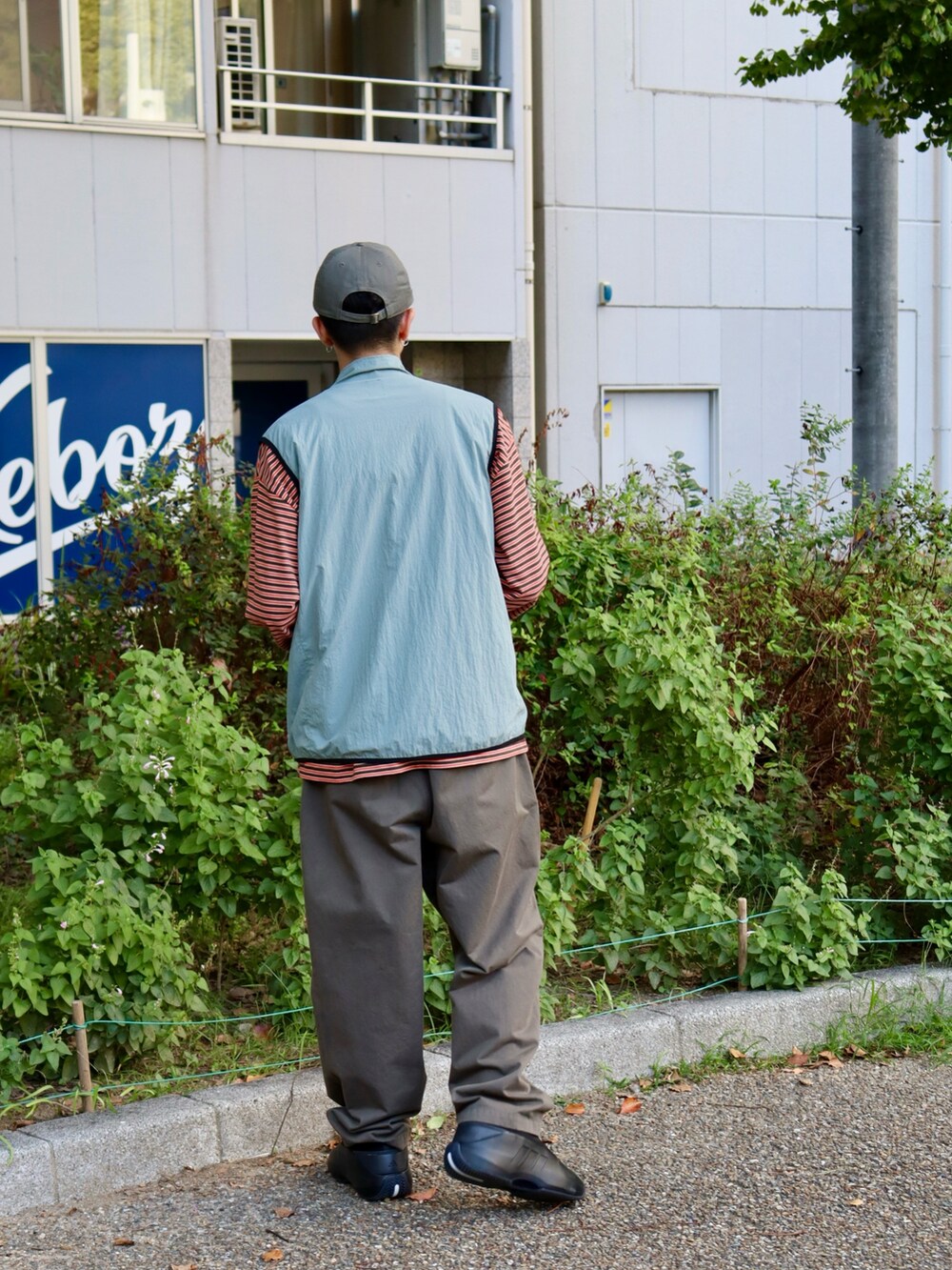 グリーン系のTシャツ/カットソー、グリーン系のチノパンツ、グリーン系のキャップを着用したメンズの秋コーディネートの3枚目の写真