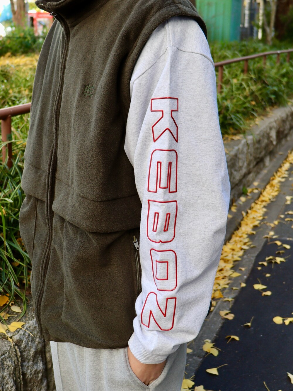 グレー系のTシャツ/カットソー、レッド系のキャップを着用したメンズの冬コーディネートの3枚目の写真