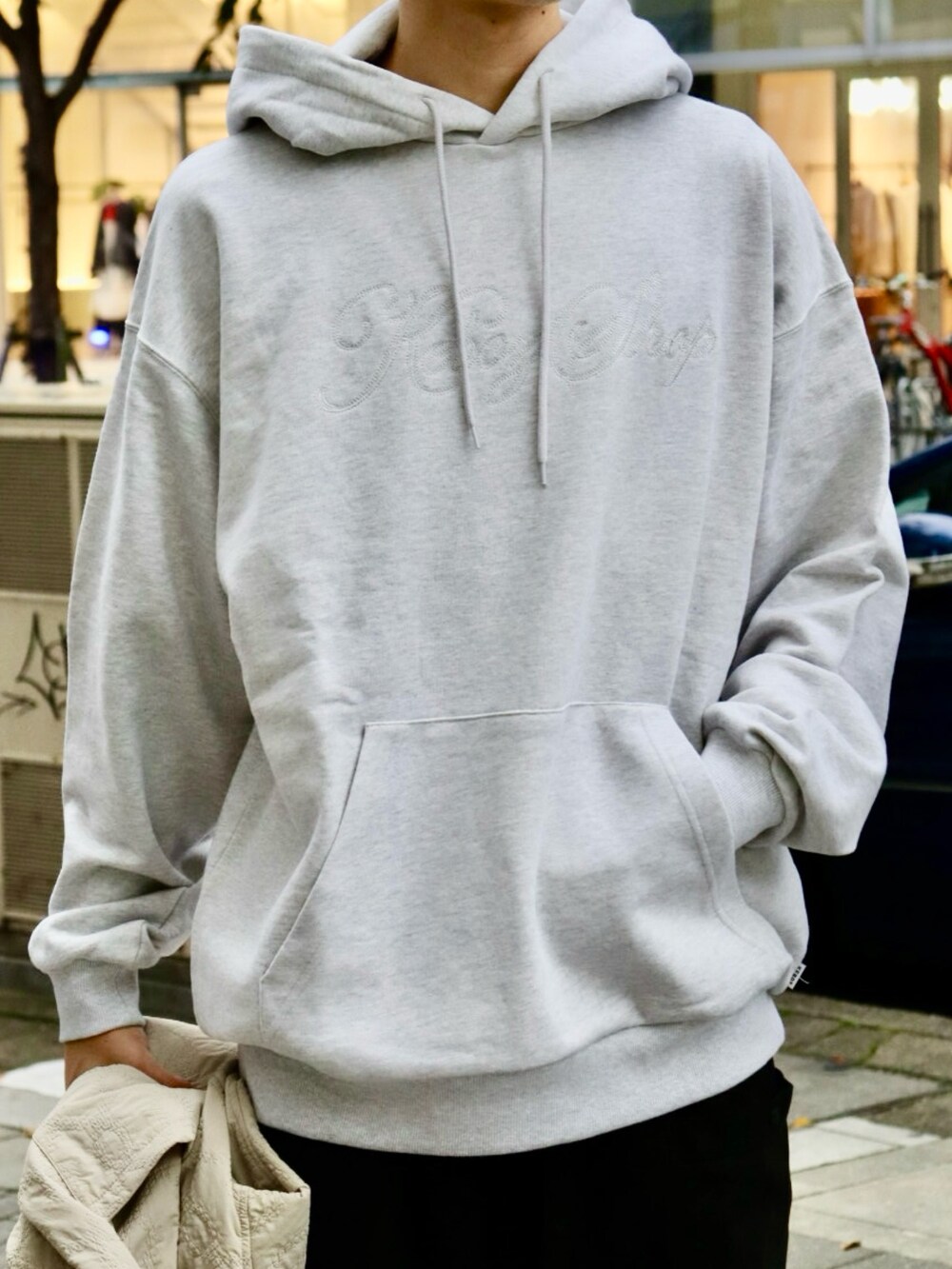 ベージュ系のブルゾン、グレー系のパーカー、ブラック系のカーゴパンツを着用したメンズの秋コーディネートの4枚目の写真