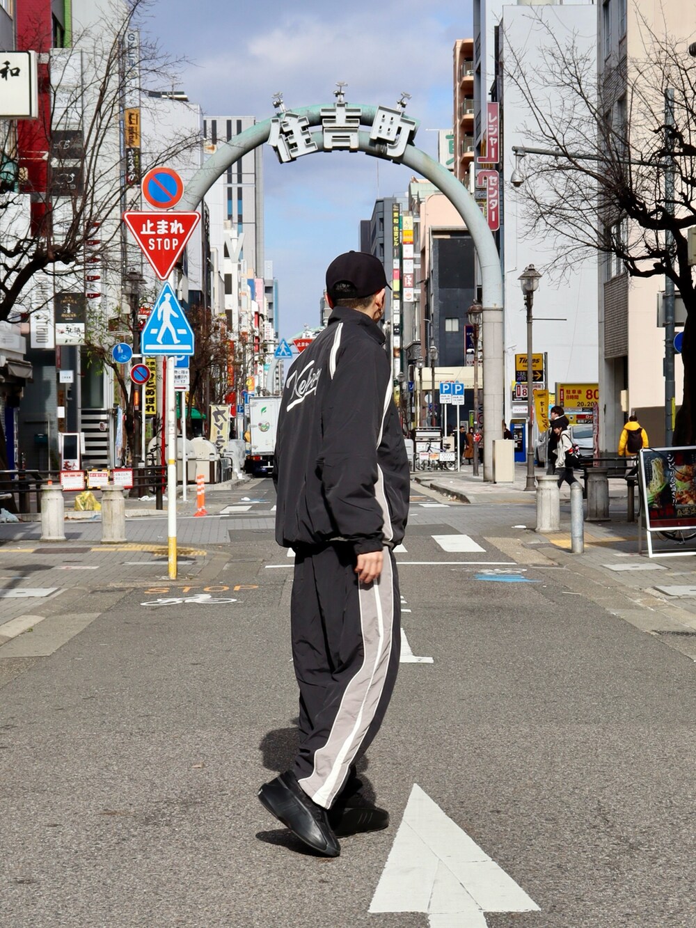 ブラック系のナイロンジャケット、ブラック系のその他パンツ、ブラック系のキャップを着用したメンズの冬コーディネートの2枚目の写真