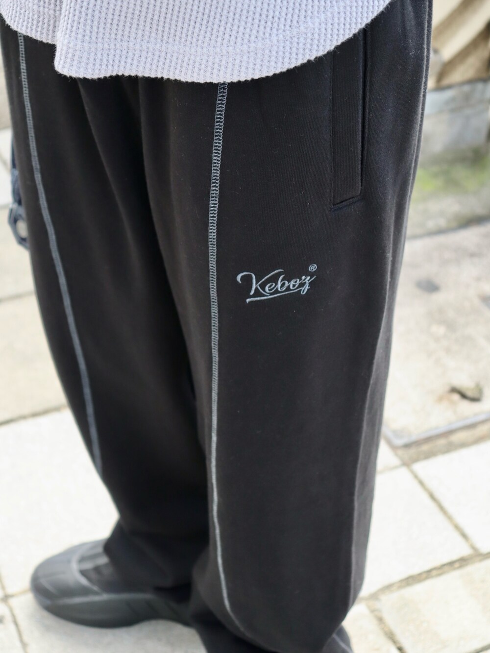 グレー系のTシャツ/カットソー、ブルー系のデニムジャケット、ブラック系のスウェットパンツを着用したメンズの秋コーディネートの4枚目の写真