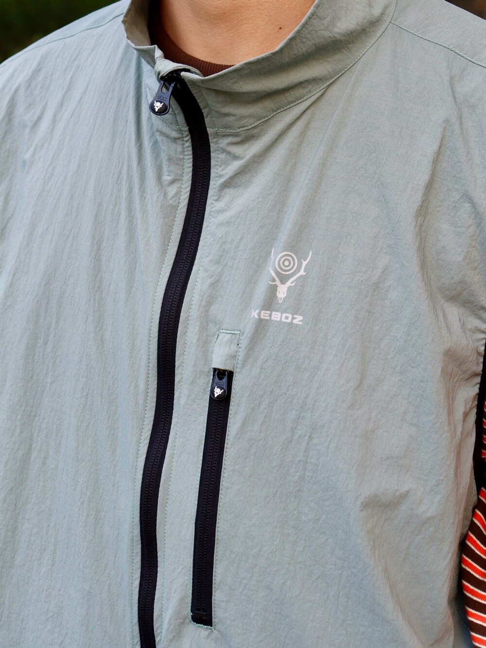 グリーン系のTシャツ/カットソー、グリーン系のチノパンツ、グリーン系のキャップを着用したメンズの秋コーディネートの4枚目の写真