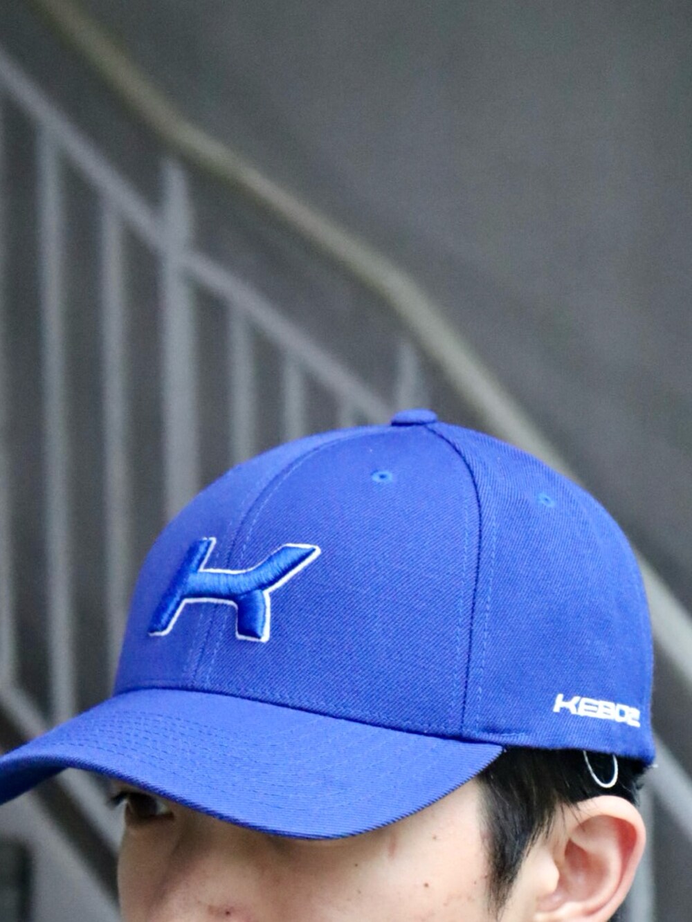 ブラック系のスウェット、ブラック系のカーゴパンツ、ブルー系のキャップを着用したメンズの秋コーディネートの4枚目の写真