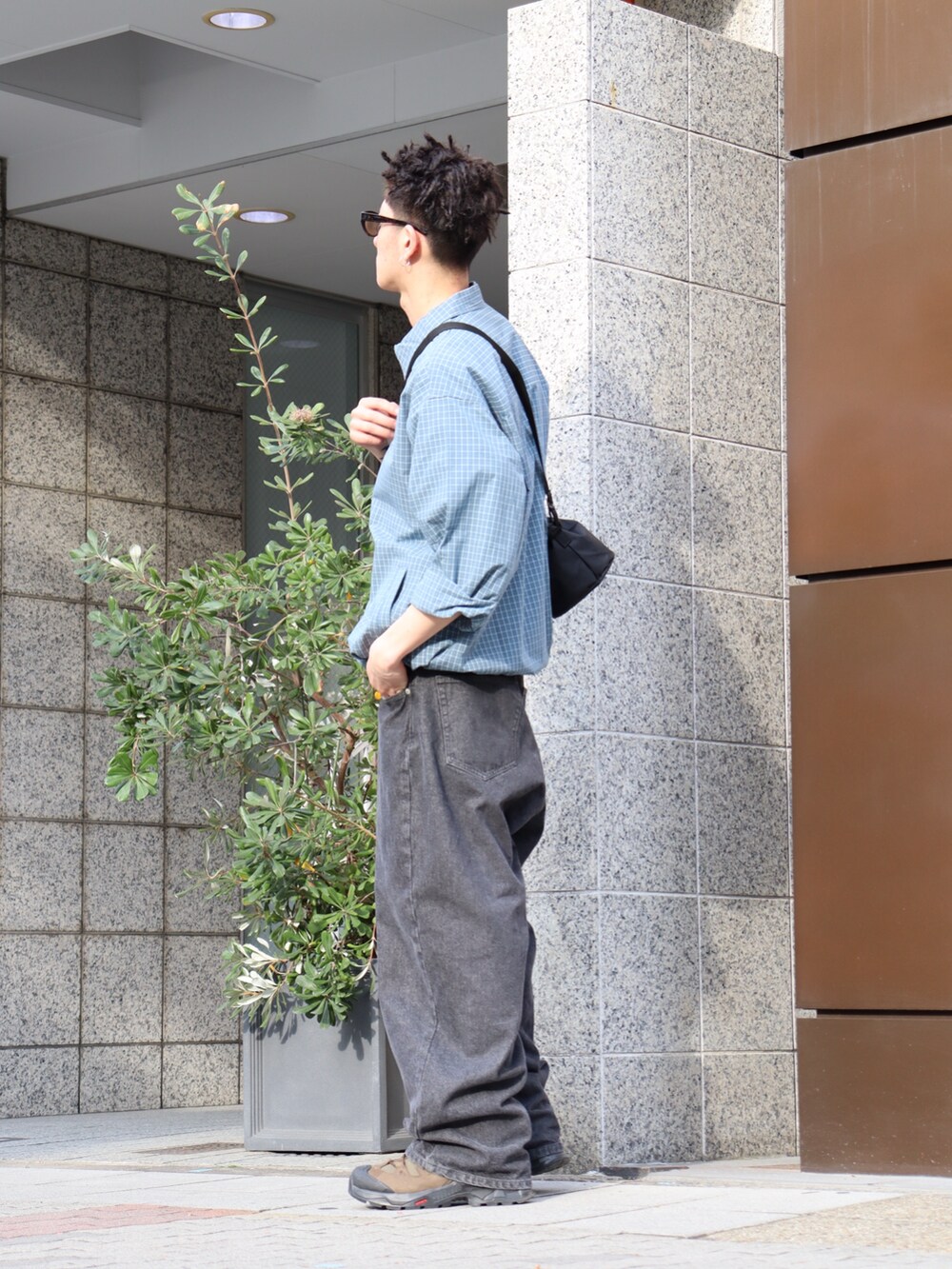 ブルー系のブルゾン、ブラック系のショルダーバッグ、ブラック系のデニムパンツを着用したメンズの春コーディネートの2枚目の写真