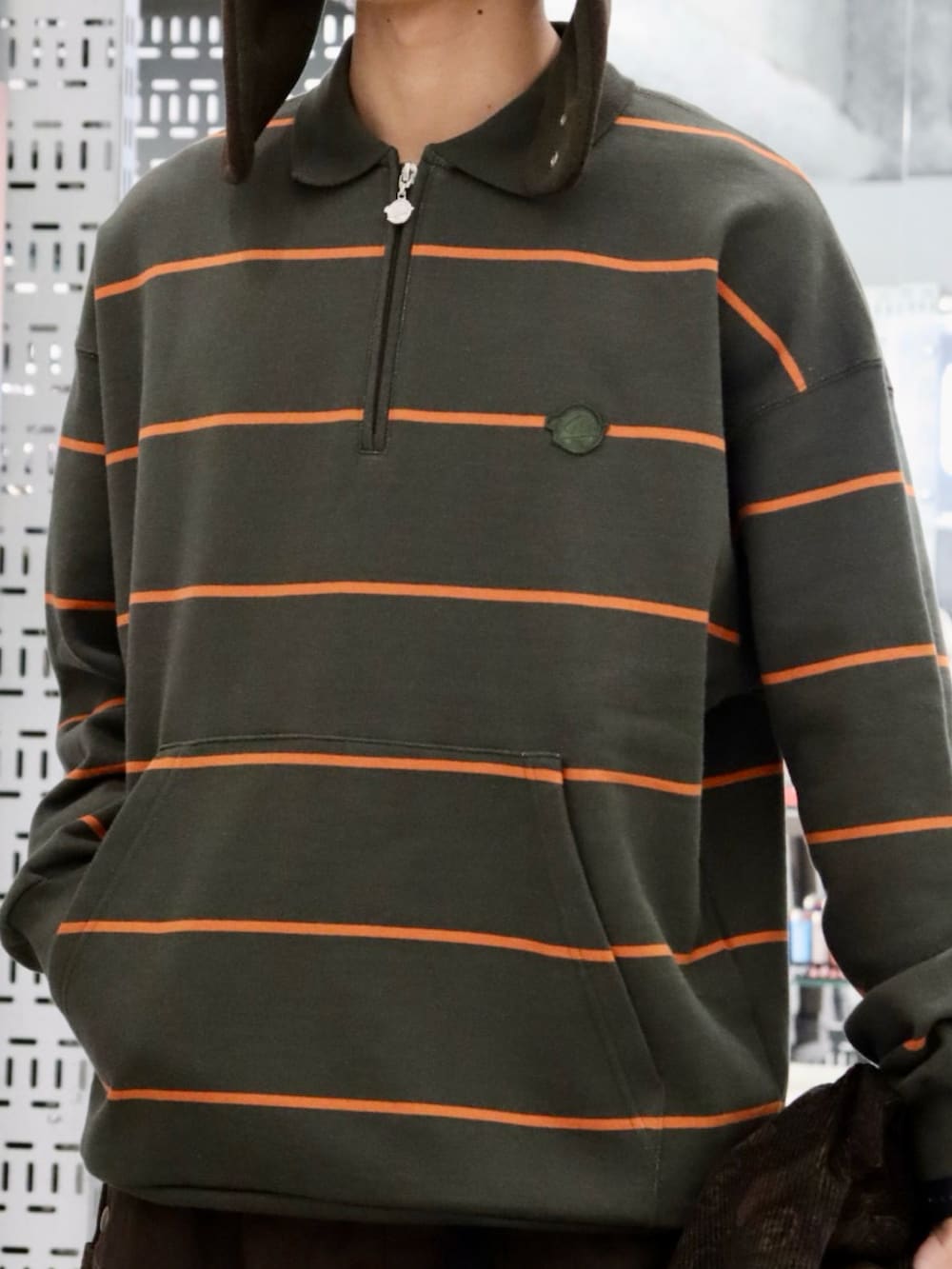 グリーン系のスウェット、ブラウン系のブルゾン、ブラウン系のハットを着用したメンズの冬コーディネートの4枚目の写真