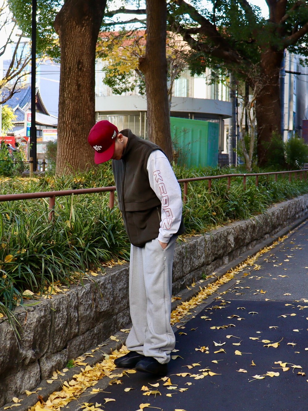 グレー系のTシャツ/カットソー、レッド系のキャップを着用したメンズの冬コーディネートの2枚目の写真
