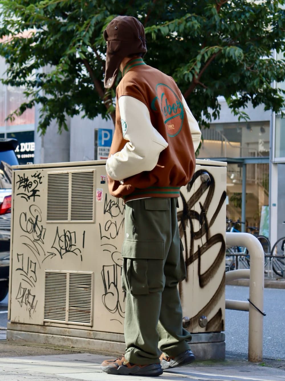 ブラウン系のスタジャン、グリーン系のスウェットパンツ、ブラウン系のハットを着用したメンズの秋コーディネートの2枚目の写真