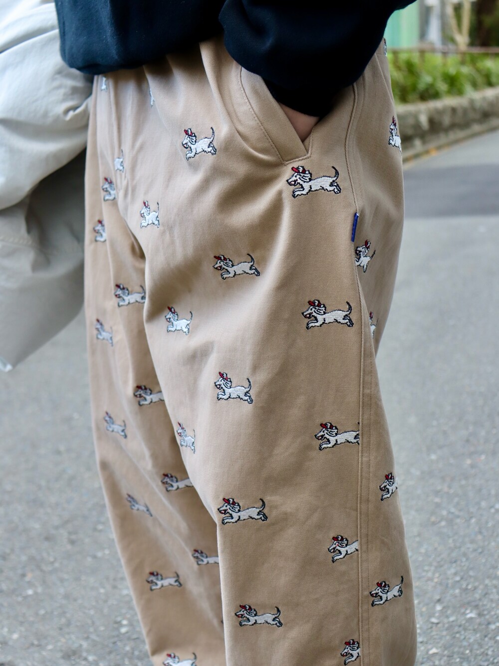 ブラック系のナイロンジャケット、ブラック系のスウェット、ベージュ系のチノパンツを着用したメンズの冬コーディネートの4枚目の写真