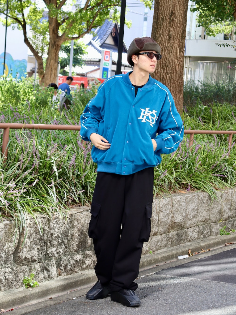 ブルー系のスタジャン、ブラック系のスウェットパンツ、ブラック系のTシャツ/カットソーを着用したメンズの秋コーディネートの3枚目の写真