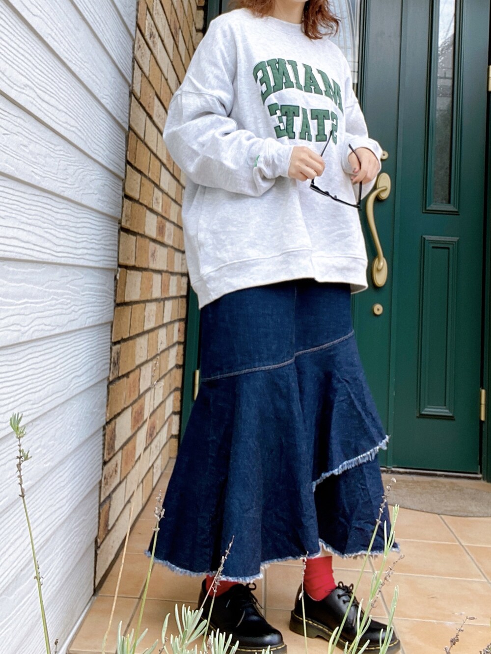 ブルー系のデニムスカート、ブラック系のドレスシューズ、グレー系のスウェットを着用したレディースの秋コーディネートの2枚目の写真