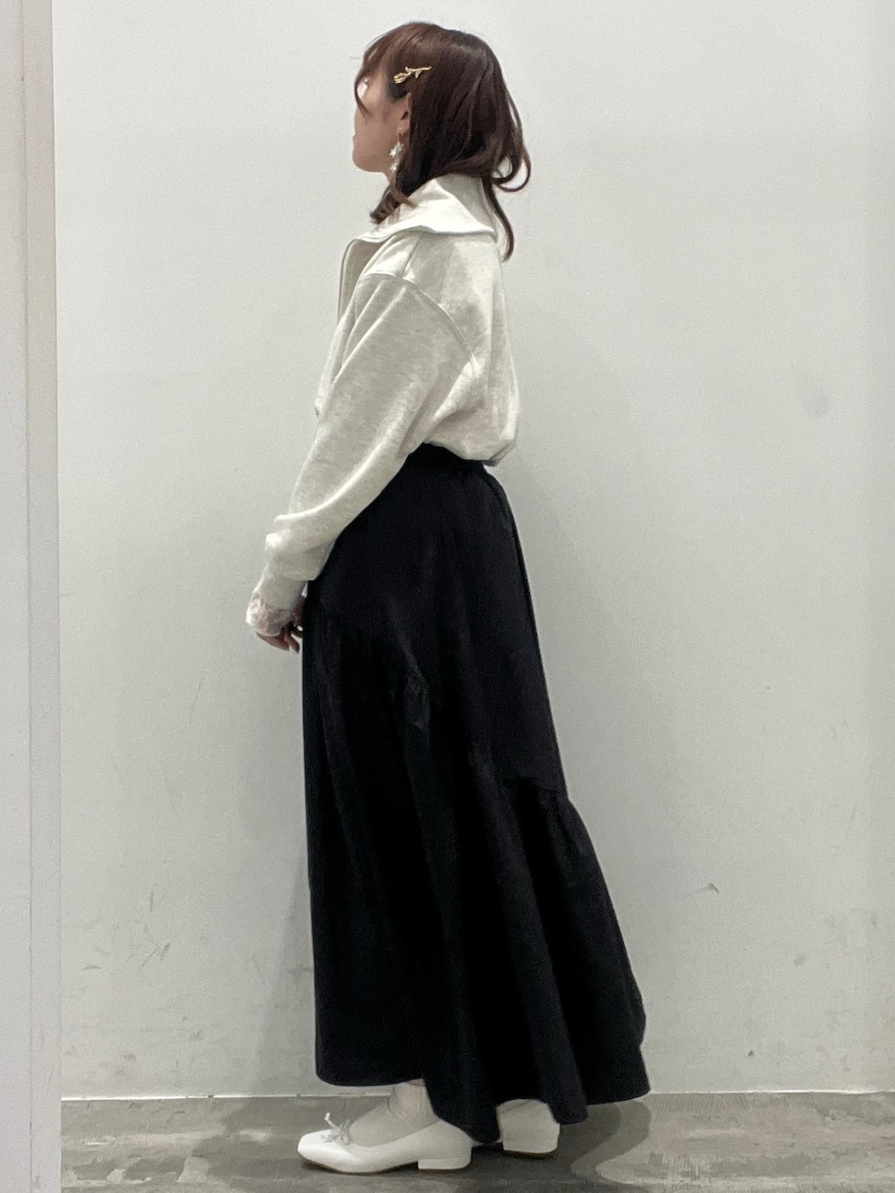 ベージュ系のTシャツ/カットソー、ホワイト系のTシャツ/カットソー、ブラック系のスカートを着用したレディースの春コーディネートの2枚目の写真