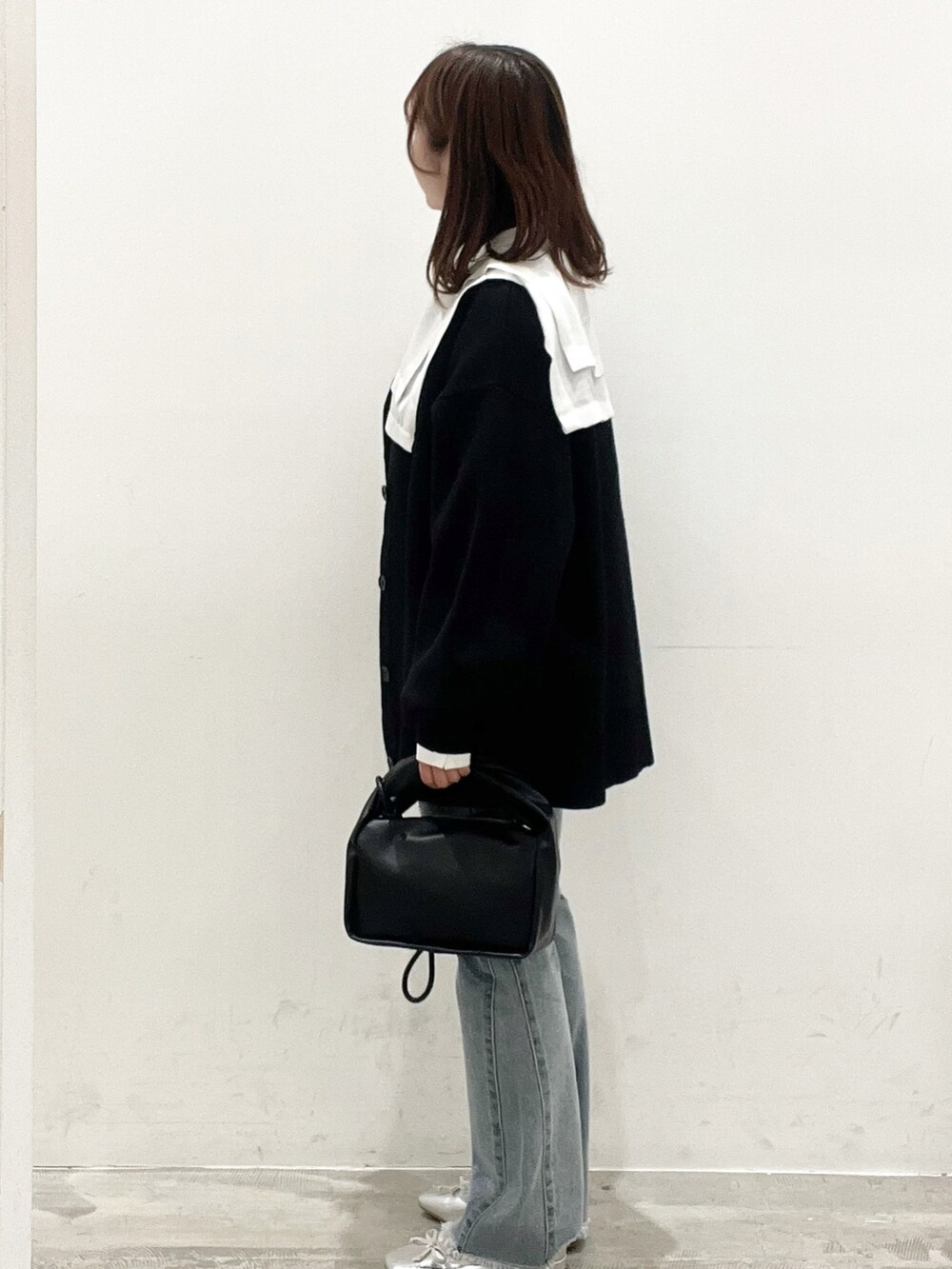 ホワイト系のシャツ/ブラウス、ブラック系のカーディガン/ボレロ、ブルー系のデニムパンツを着用したレディースの春コーディネートの3枚目の写真