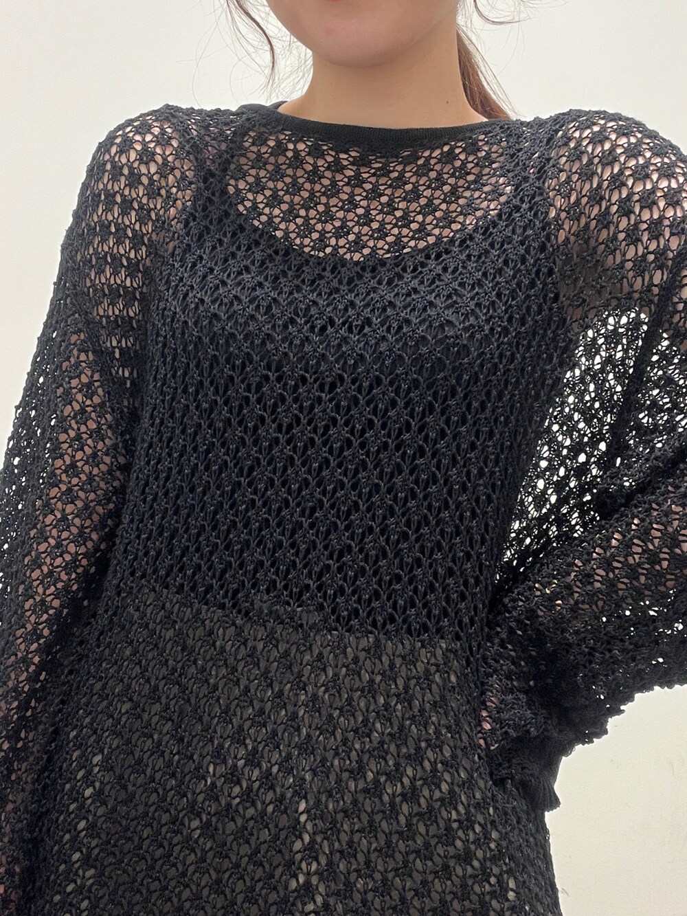 ブラック系のニット/セーター、グリーン系のその他パンツ、ブラック系のショルダーバッグを着用したレディースの春コーディネートの4枚目の写真