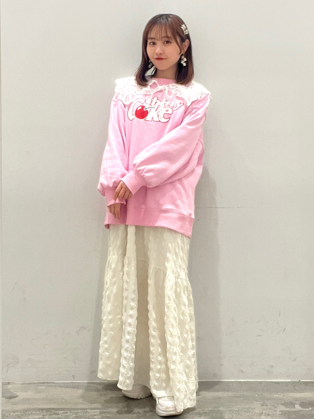 ピンク系のトップス、ホワイト系のワンピース、ホワイト系のカーディガン/ボレロを着用したレディースの春コーディネートの2枚目の写真