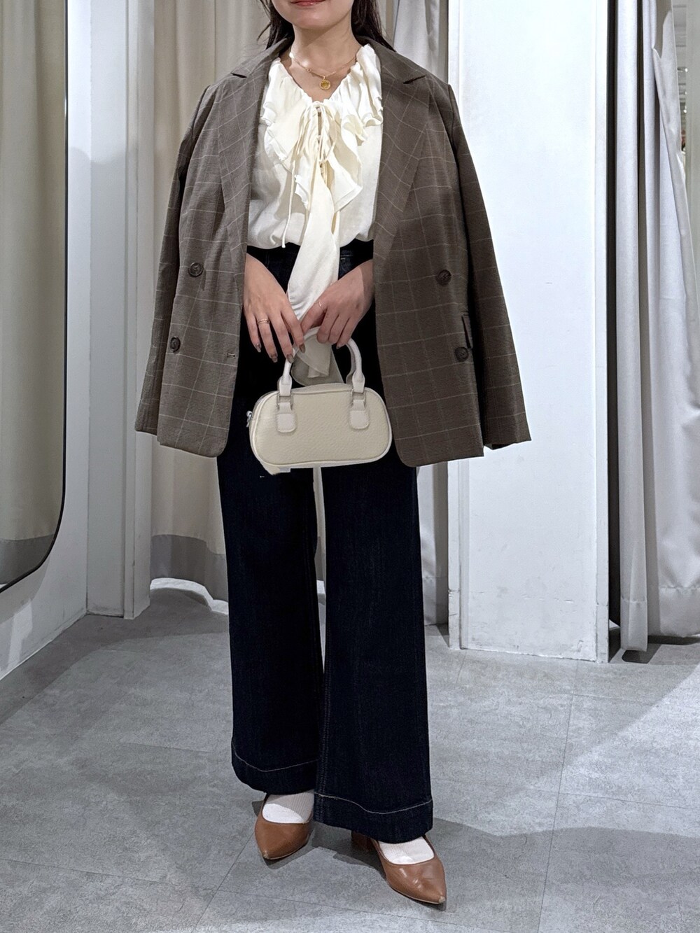 ブラウン系のテーラードジャケット、ホワイト系のシャツ/ブラウス、ブルー系のデニムパンツを着用したレディースの秋コーディネートの5枚目の写真