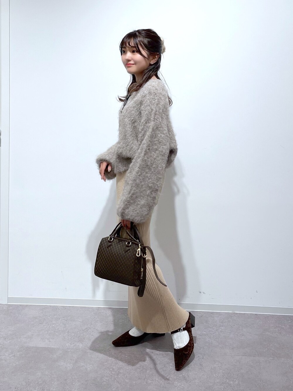 ベージュ系のニット/セーター、ゴールド系のスカート、ブラウン系のバレエシューズを着用したレディースの冬コーディネートの2枚目の写真