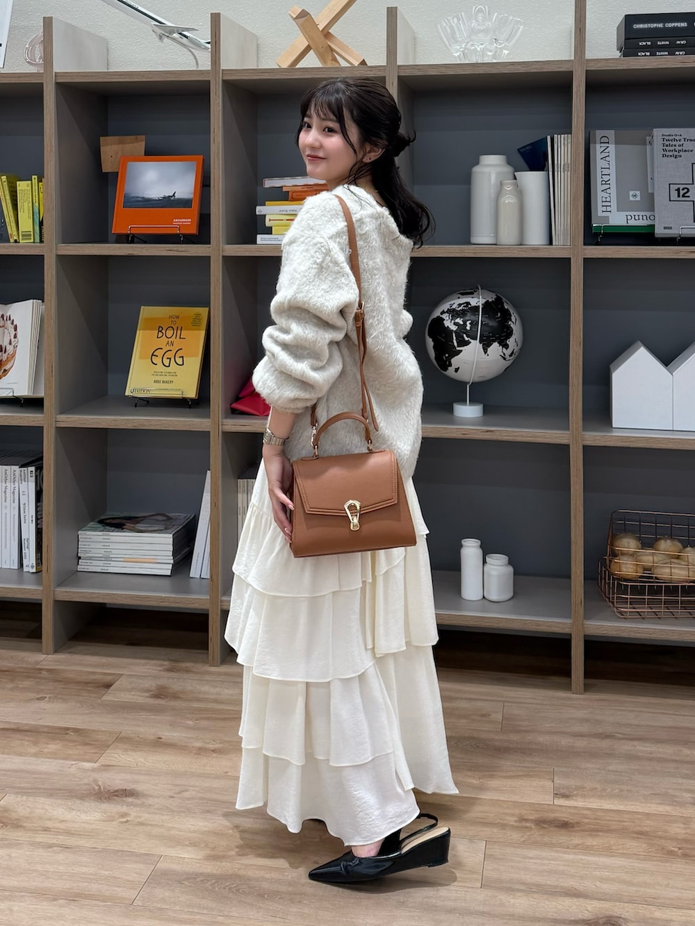 ベージュ系のニット/セーター、ホワイト系のスカート、ベージュ系のトートバッグを着用したレディースの秋コーディネートの2枚目の写真