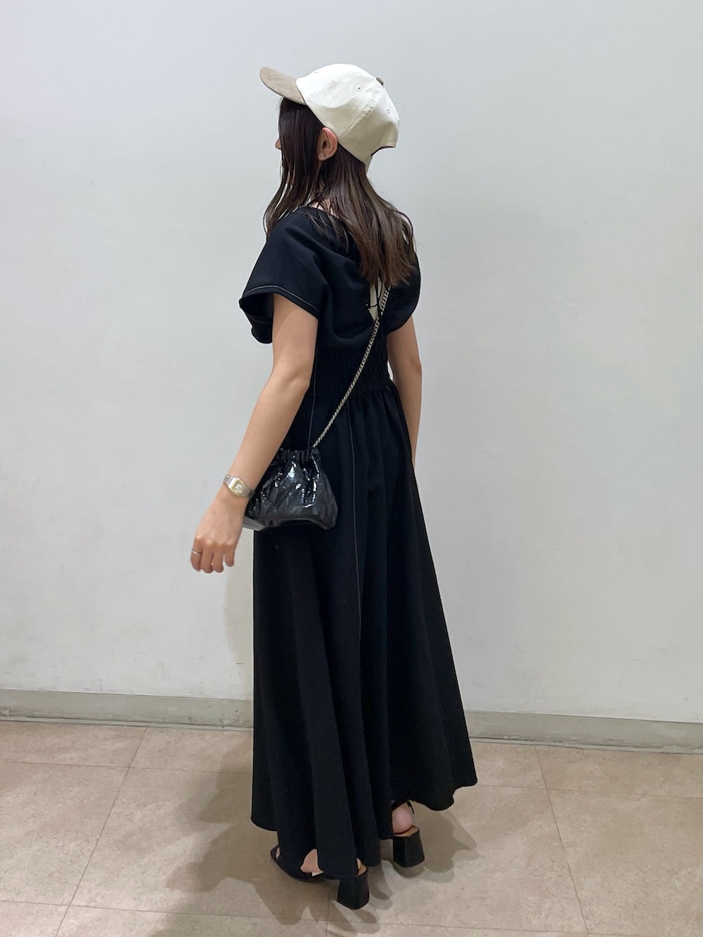 ブラック系のワンピース、ブラック系のショルダーバッグ、ブラック系のサンダルを着用したレディースの夏コーディネートの2枚目の写真