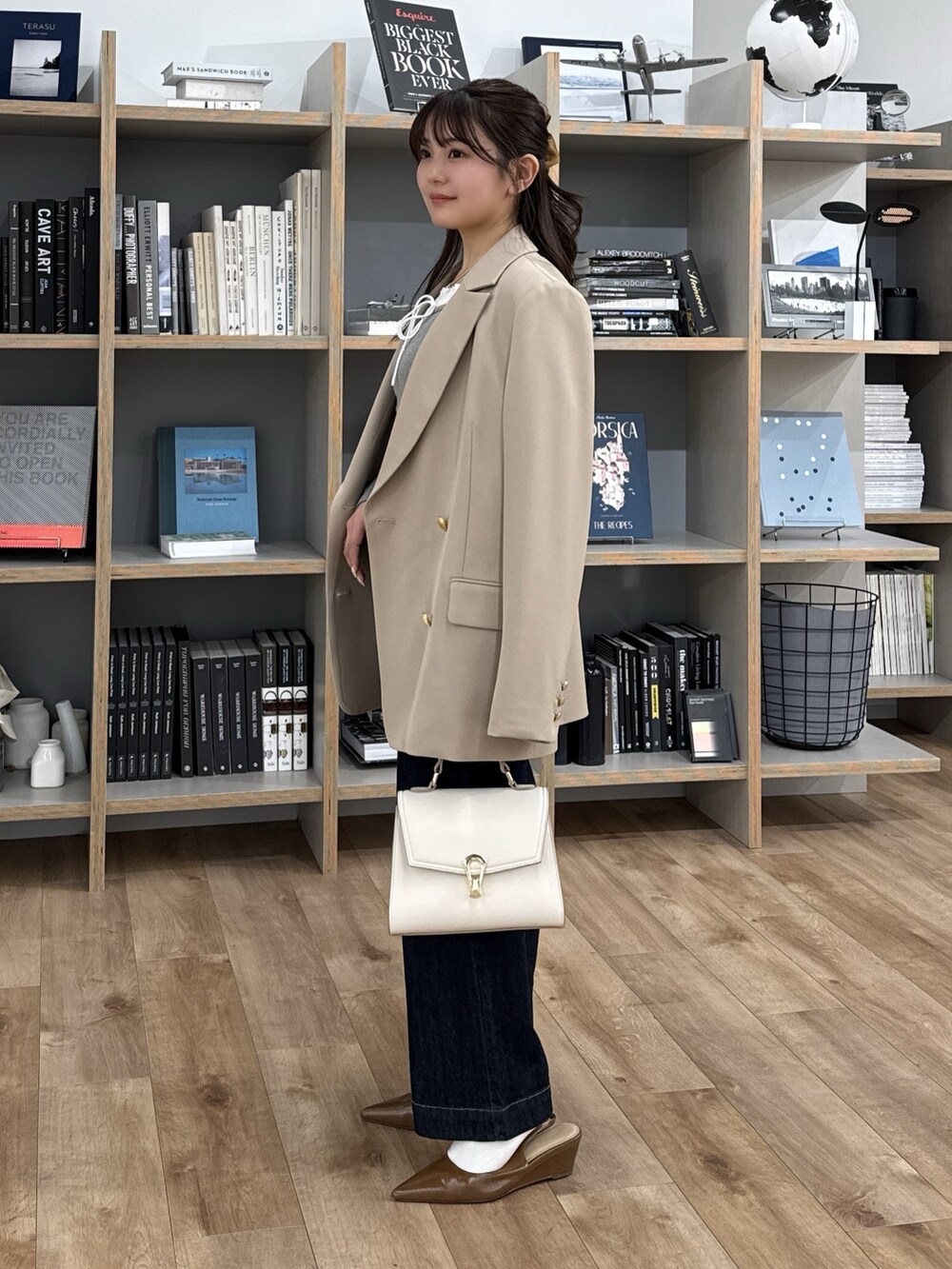 グレー系のTシャツ/カットソー、ブラウン系のパンプス、ホワイト系のトートバッグを着用したレディースの冬コーディネートの2枚目の写真