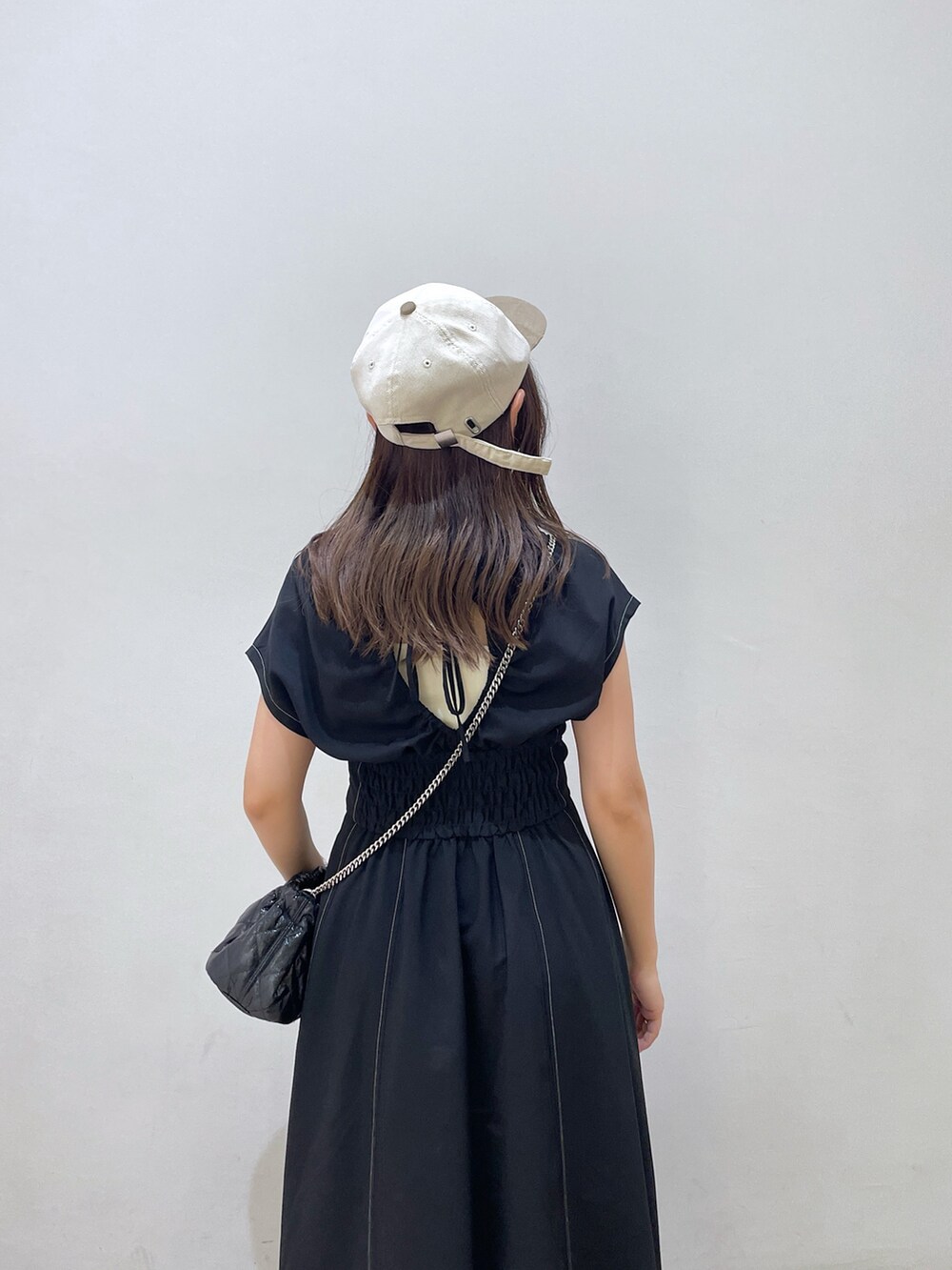 ブラック系のワンピース、ブラック系のショルダーバッグ、ブラック系のサンダルを着用したレディースの夏コーディネートの6枚目の写真