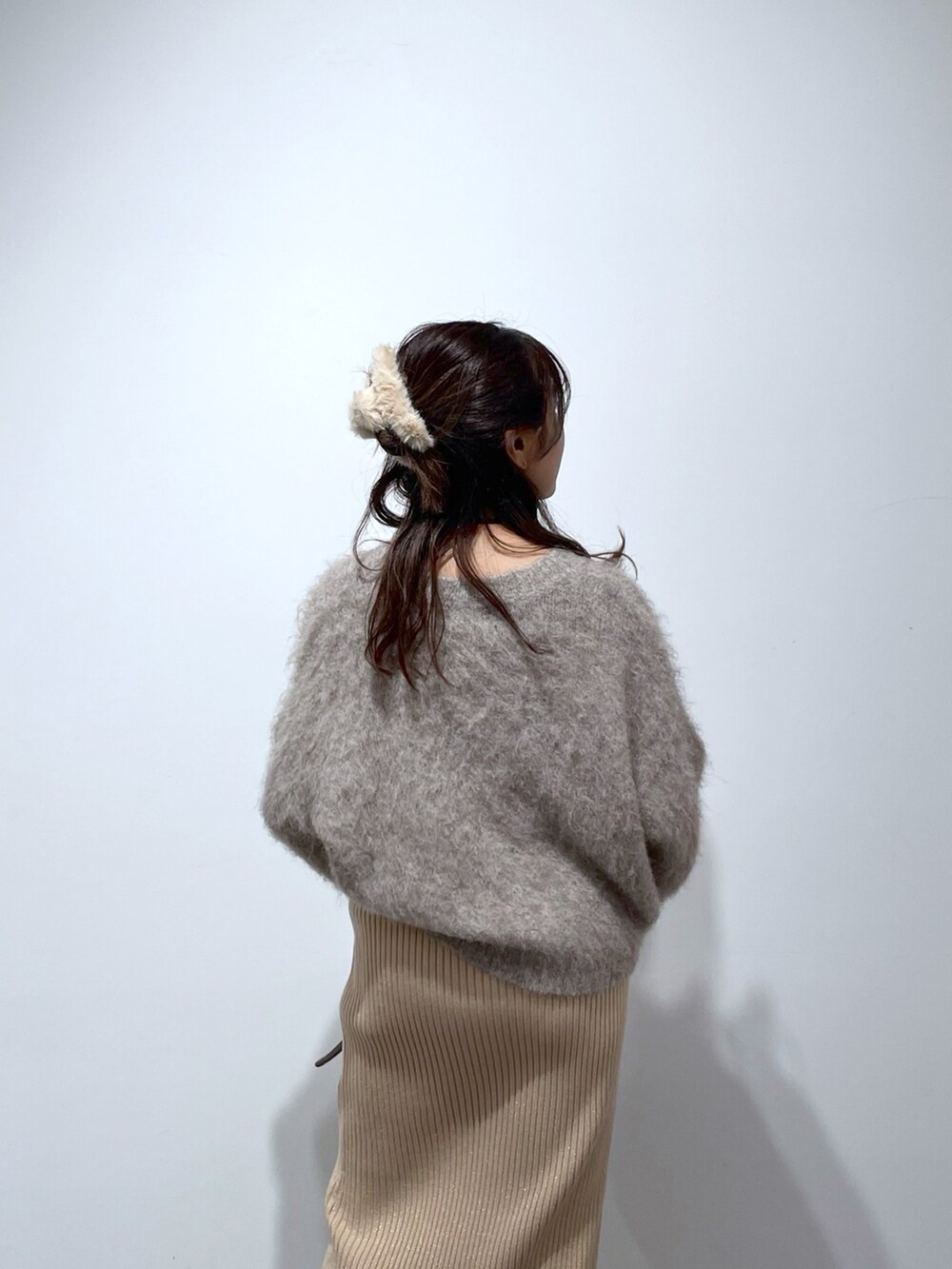 ベージュ系のニット/セーター、ゴールド系のスカート、ブラウン系のバレエシューズを着用したレディースの冬コーディネートの6枚目の写真