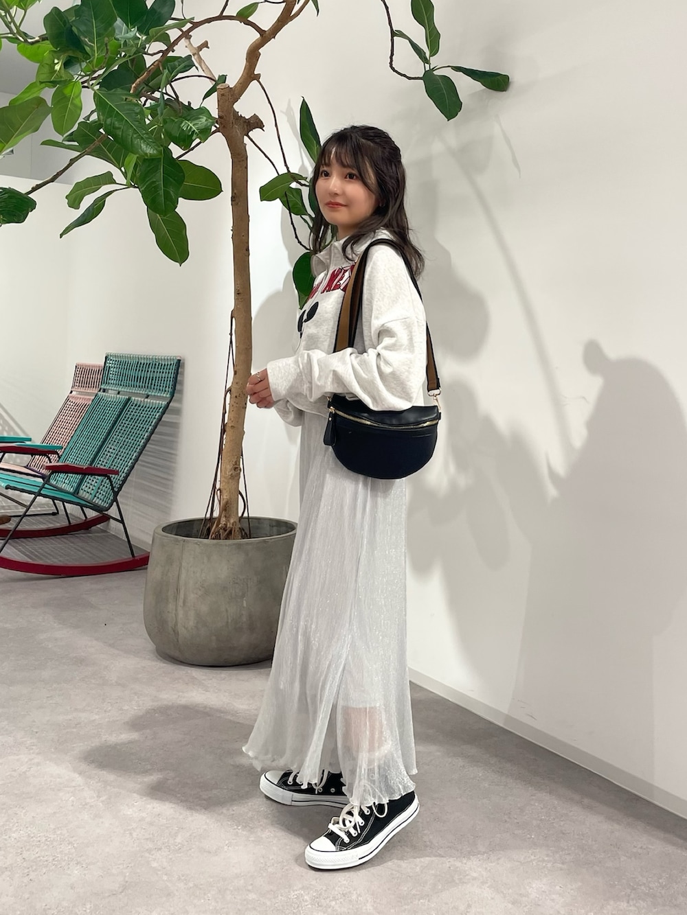 シルバー系のスカート、ブラック系のボディバッグ/ウエストポーチ、グレー系のスウェットを着用したレディースの秋コーディネートの2枚目の写真