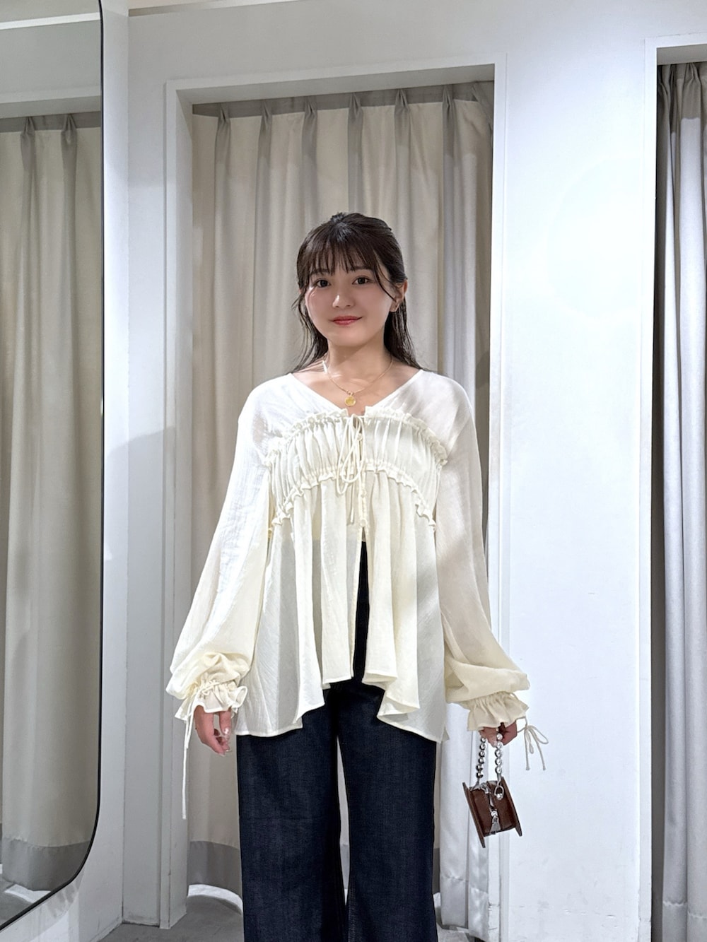 ホワイト系のシャツ/ブラウス、ブルー系のデニムパンツ、ブラック系のパンプスを着用したレディースの秋コーディネートの5枚目の写真