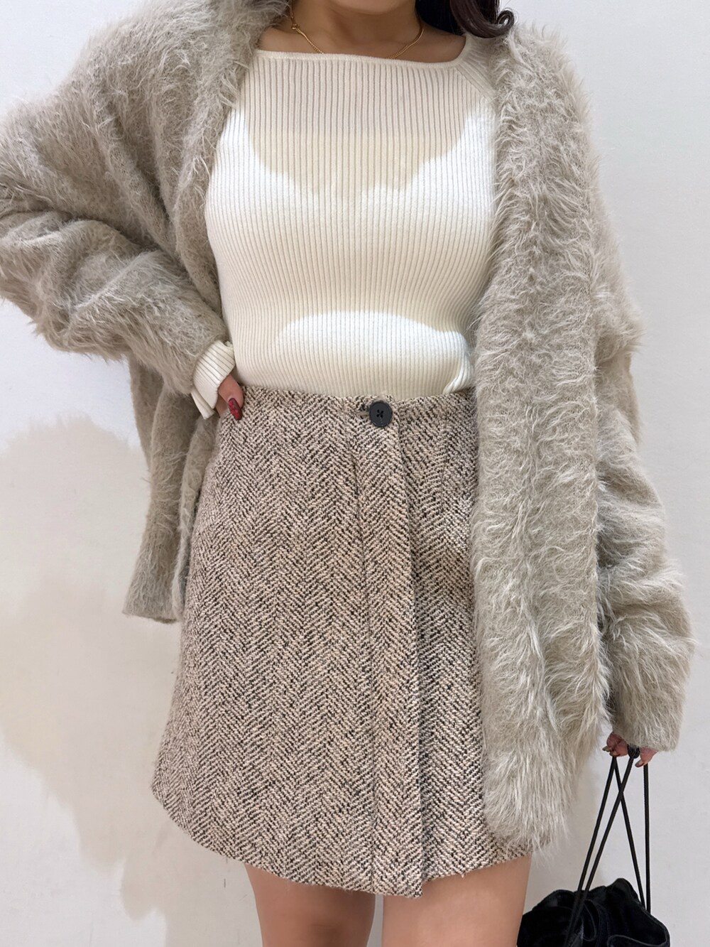 ベージュ系のカーディガン/ボレロ、ホワイト系のニット/セーター、ベージュ系のスカートを着用したレディースの冬コーディネートの8枚目の写真