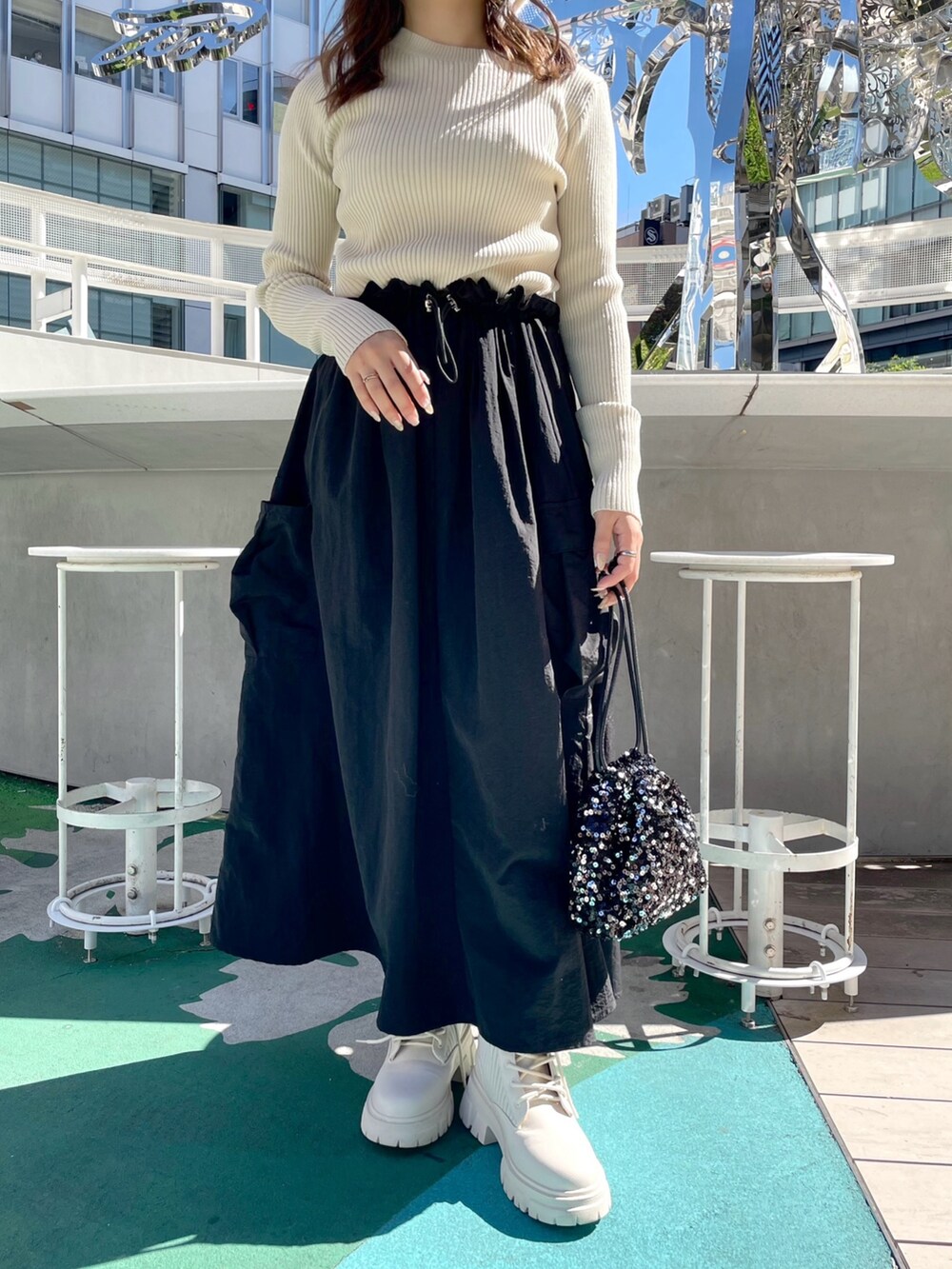 ホワイト系のワンピース、ブラック系のハンドバッグ、ホワイト系のブーツを着用したレディースの秋コーディネートの6枚目の写真