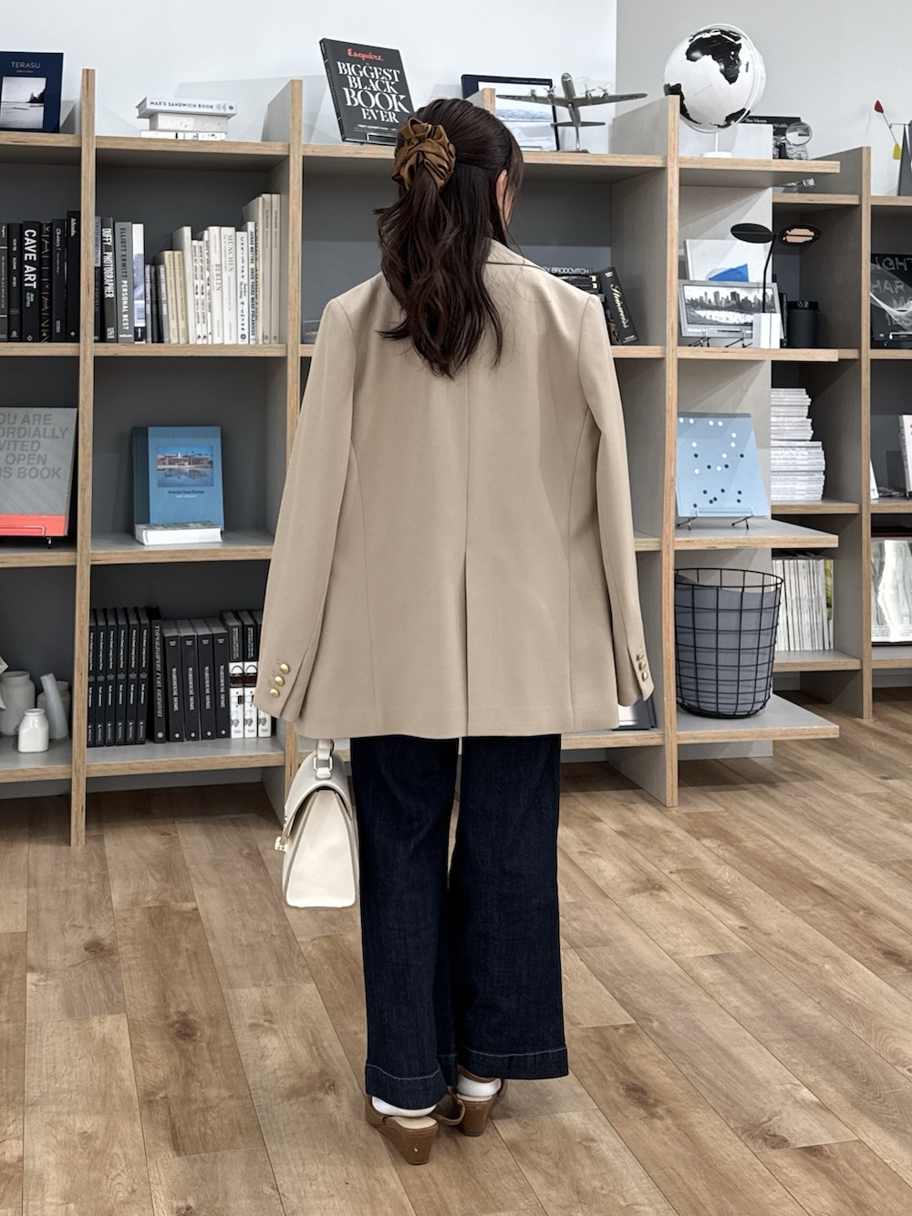 グレー系のTシャツ/カットソー、ブラウン系のパンプス、ホワイト系のトートバッグを着用したレディースの冬コーディネートの3枚目の写真