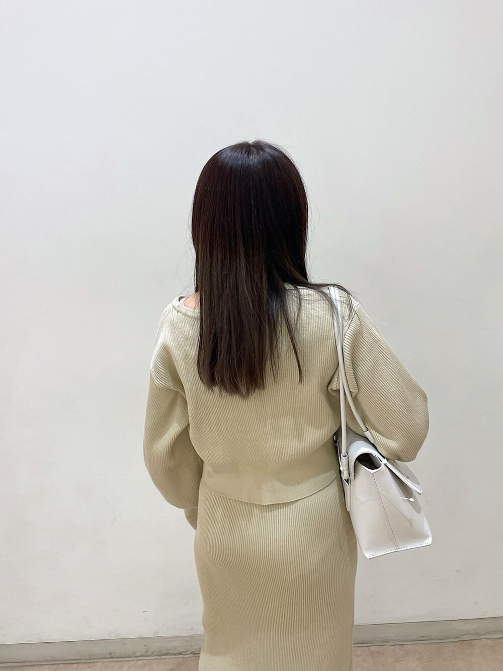 ベージュ系のワンピース、ベージュ系のカーディガン/ボレロ、ブラック系のバレエシューズを着用したレディースの春コーディネートの5枚目の写真